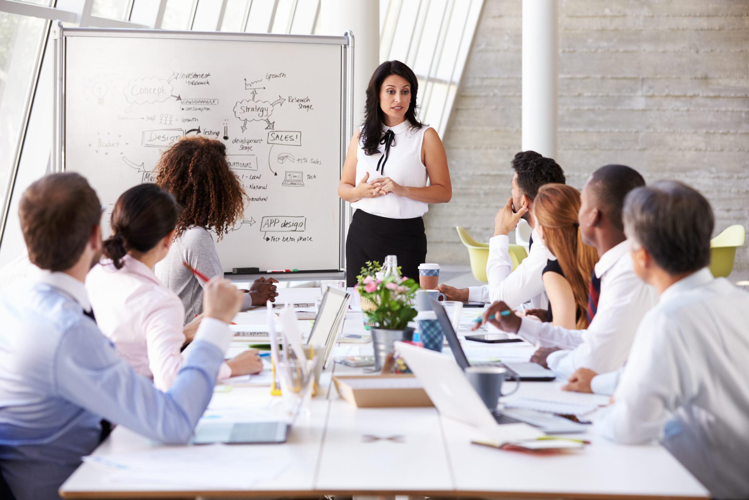 Hispanic,Businesswoman,Leading,Meeting,At,Boardroom,Table